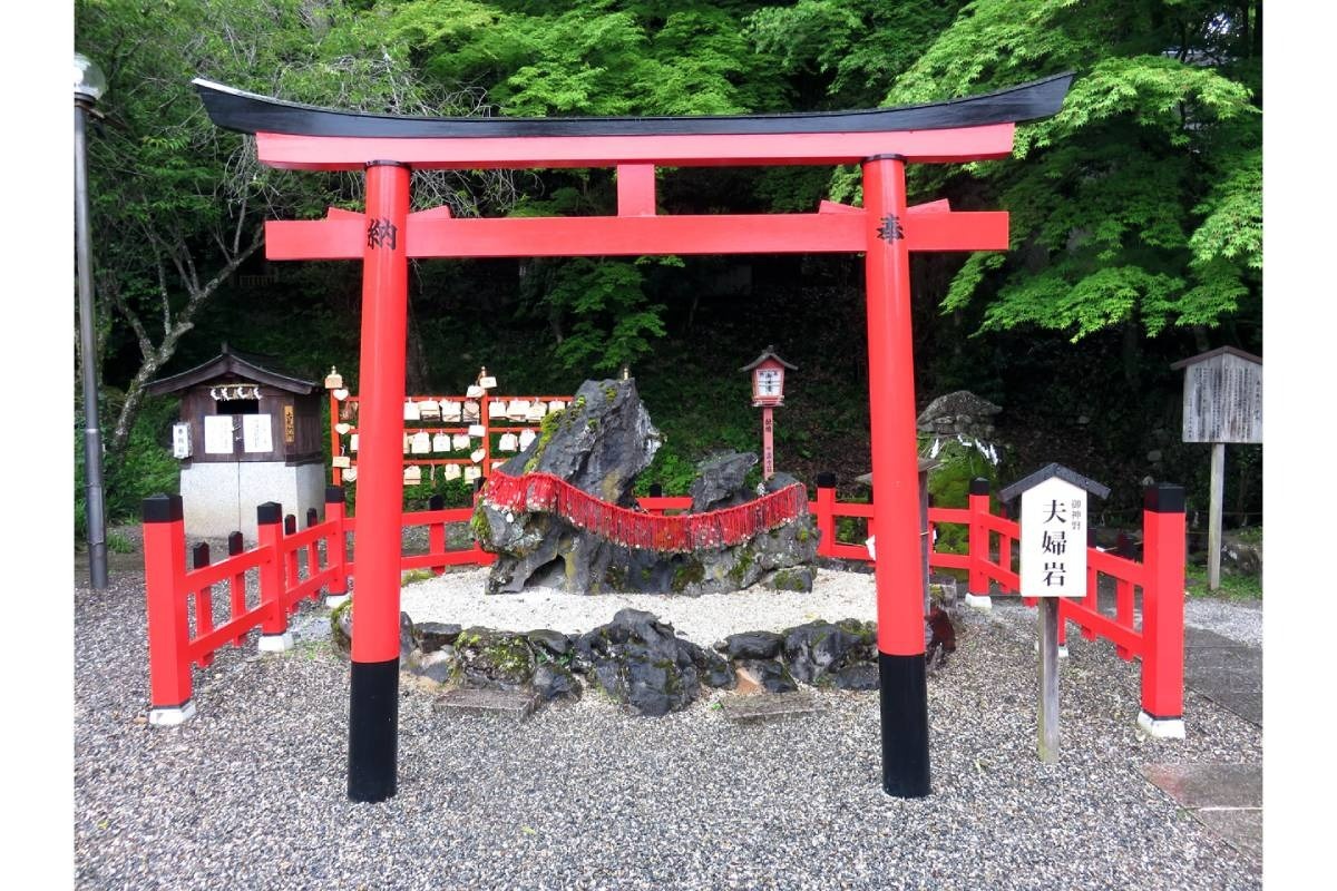 お守りに付いている赤い糸を夫婦岩に結び付けて良縁成就を祈願