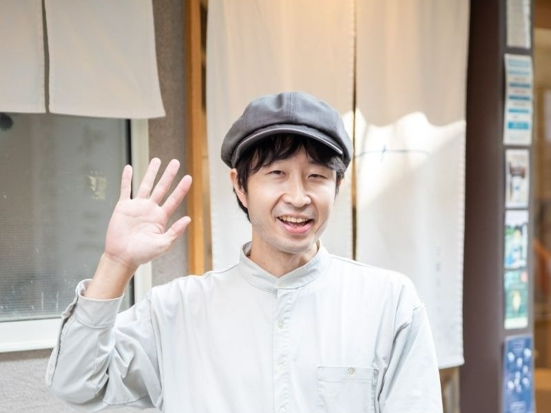 帽子をかぶって手を上げている男性