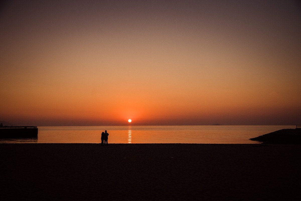 水平線に沈む美しい夕陽を望む