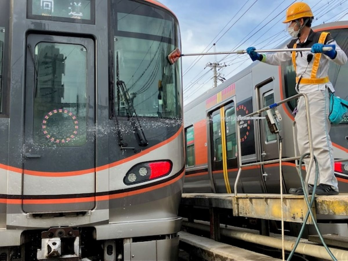 ブラシ等を使って先頭車両を清掃する様子