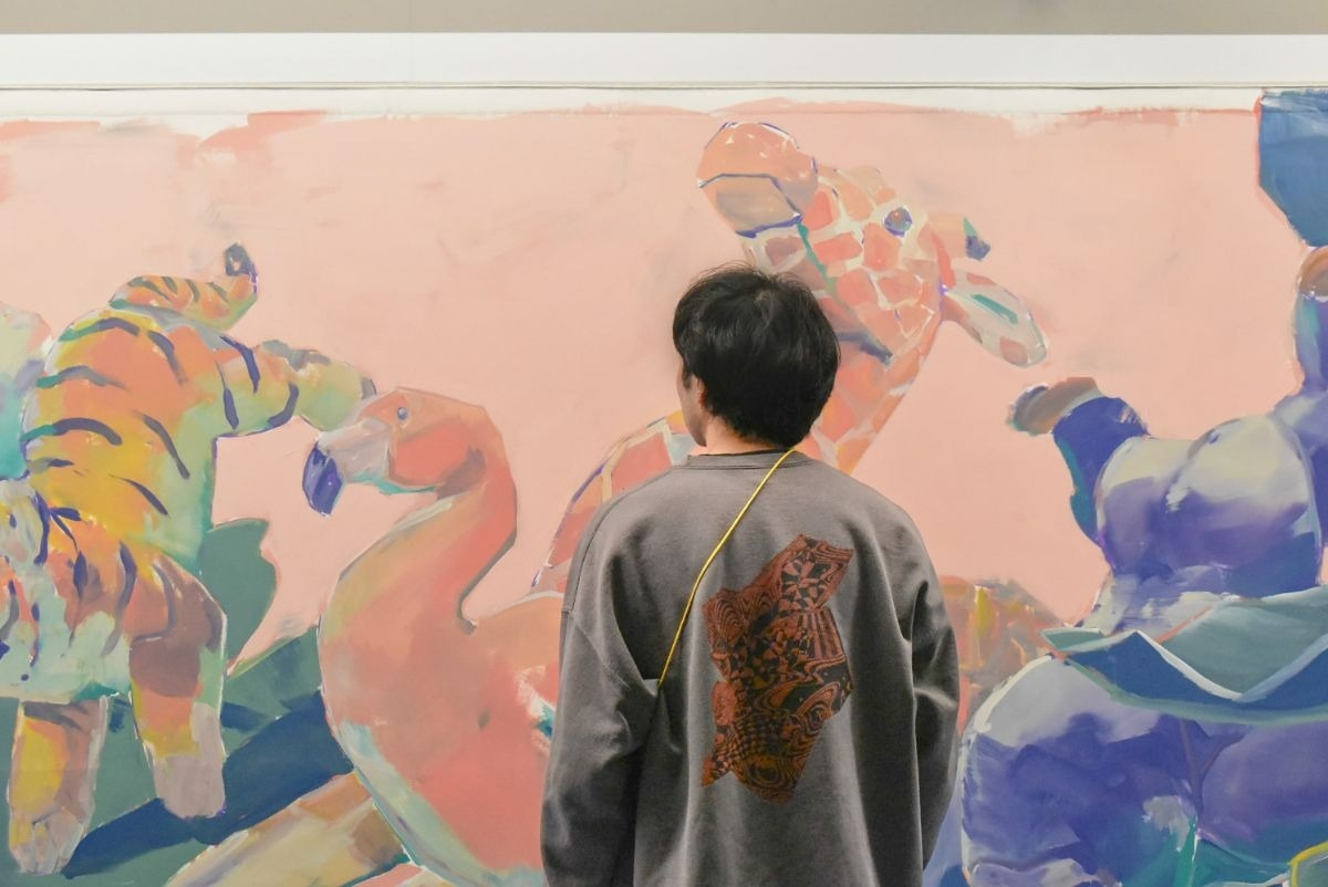 絵画の前に立つ男性の後ろ姿