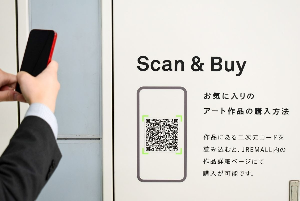 スマートフォンを構える手とQRコード
