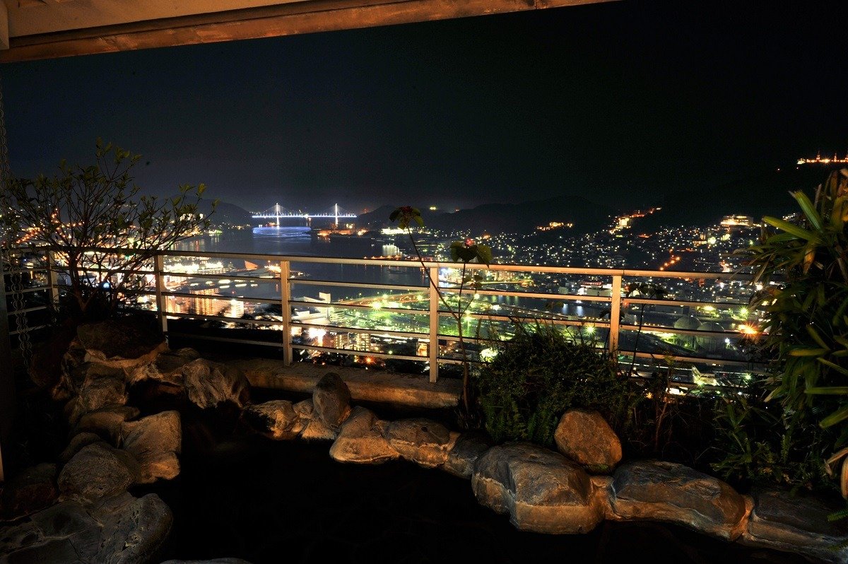 展望露天風呂から長崎市街の夜景を一望。長崎港やライトアップされた女神大橋も見えます