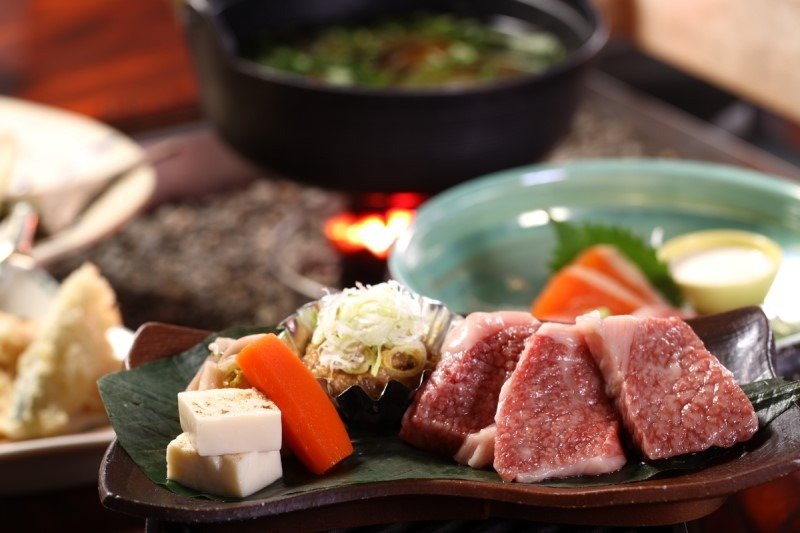 夕食には囲炉裏の火で炙った名物の飛騨牛が出るプランも