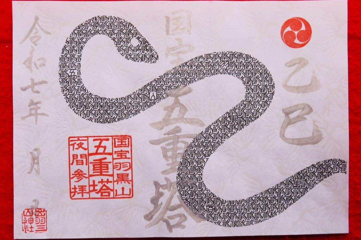 篆書体の「神」で蛇が描かれている「夜間参拝限定特別銀字御朱印」。写真は8月15日までのデザイン