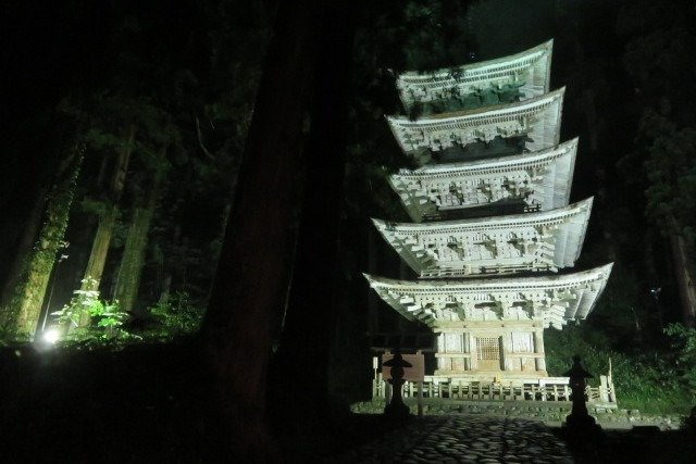 白色の照明でライトアップされる羽黒山五重塔