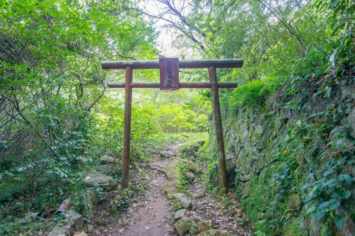 「生駒稲荷本院」と記された鳥居をくぐります。右側は石垣