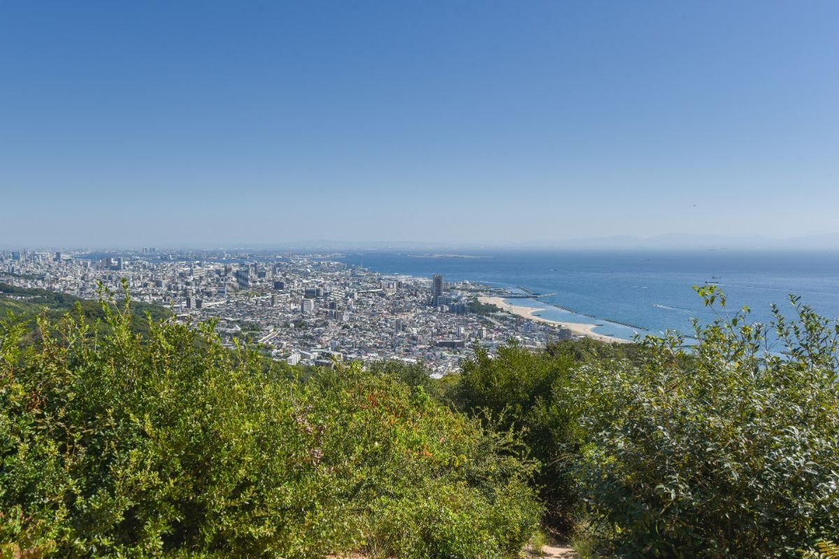 左に町、右に海が広がる、鉄拐山山頂からの景色の写真