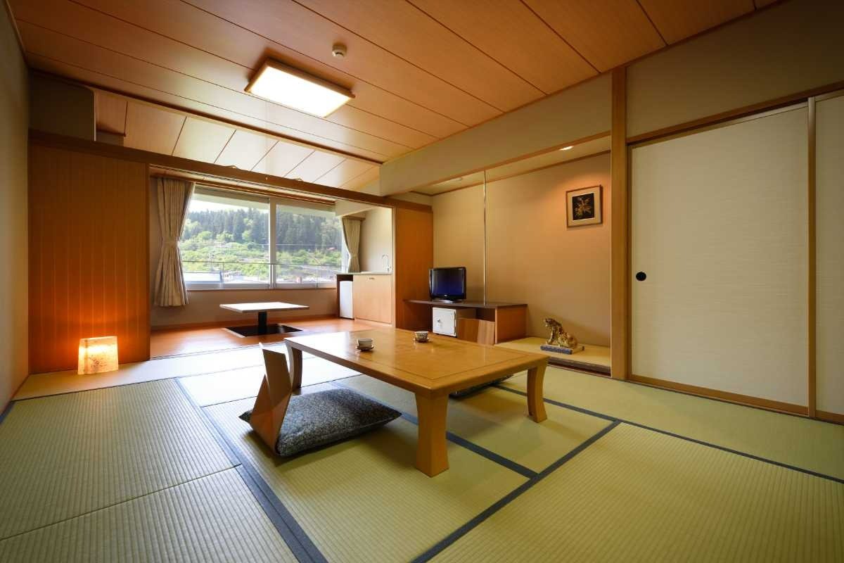 窓際に掘りごたつがある、ゆったりとした客室（本館和室12畳）