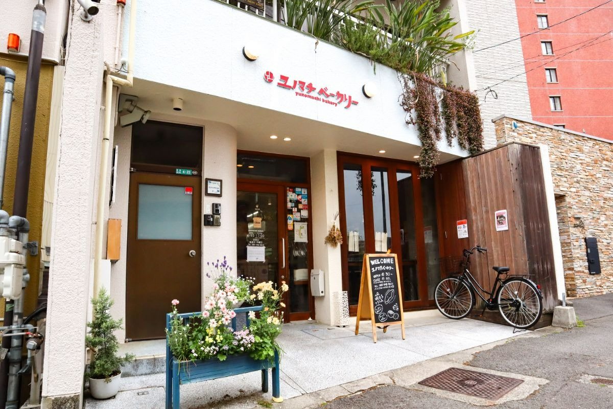 白い壁、かわいいロゴの外観が目印