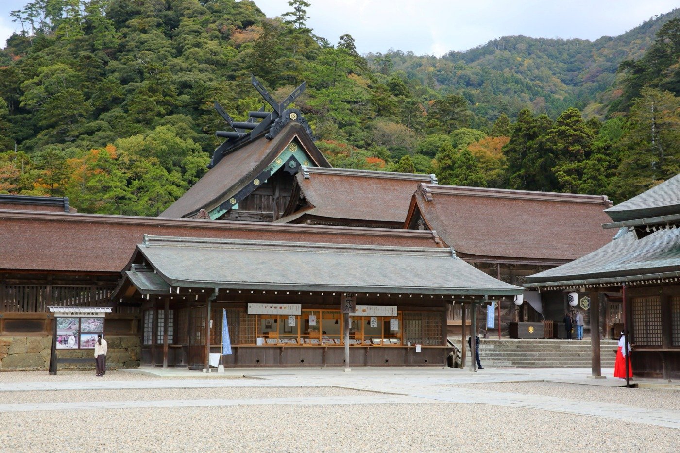御守所と八足門の屋根の奥に望む、大社造りの御本殿